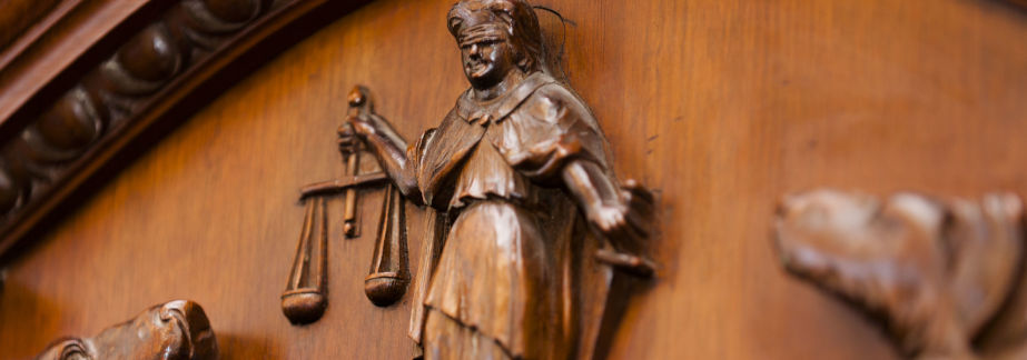 Anti-Money Laundering - wooden carving of lady justice